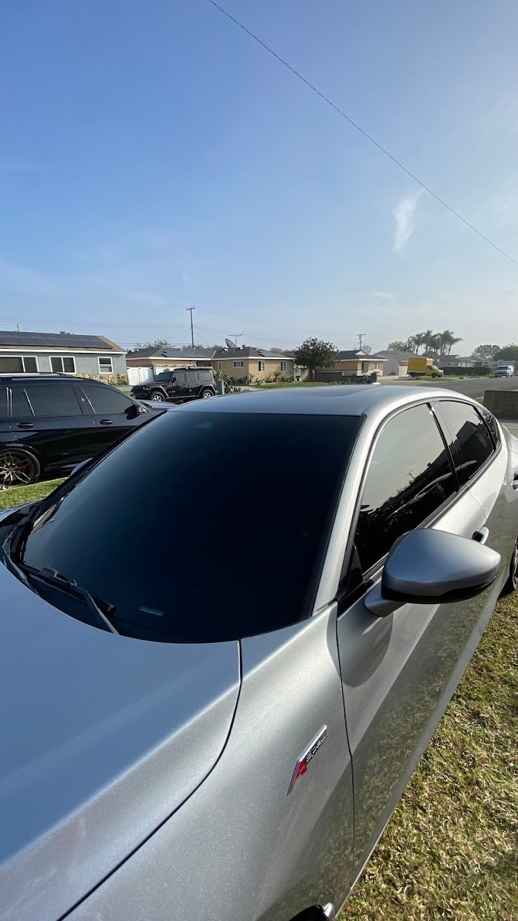Silver car parked on street with residential neighborhood in background
