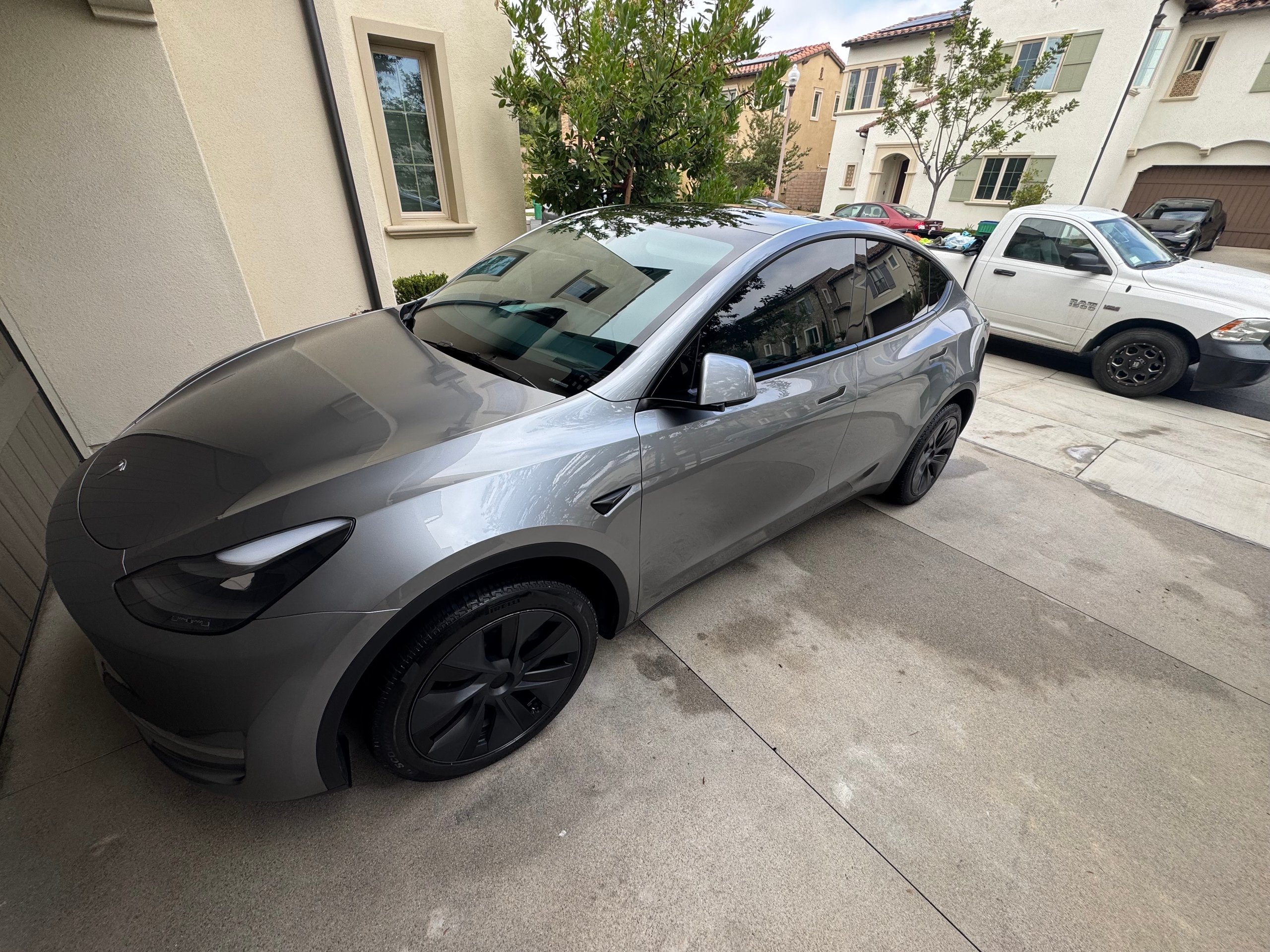 Silver Tesla Model Y parked on residential street with black wheels